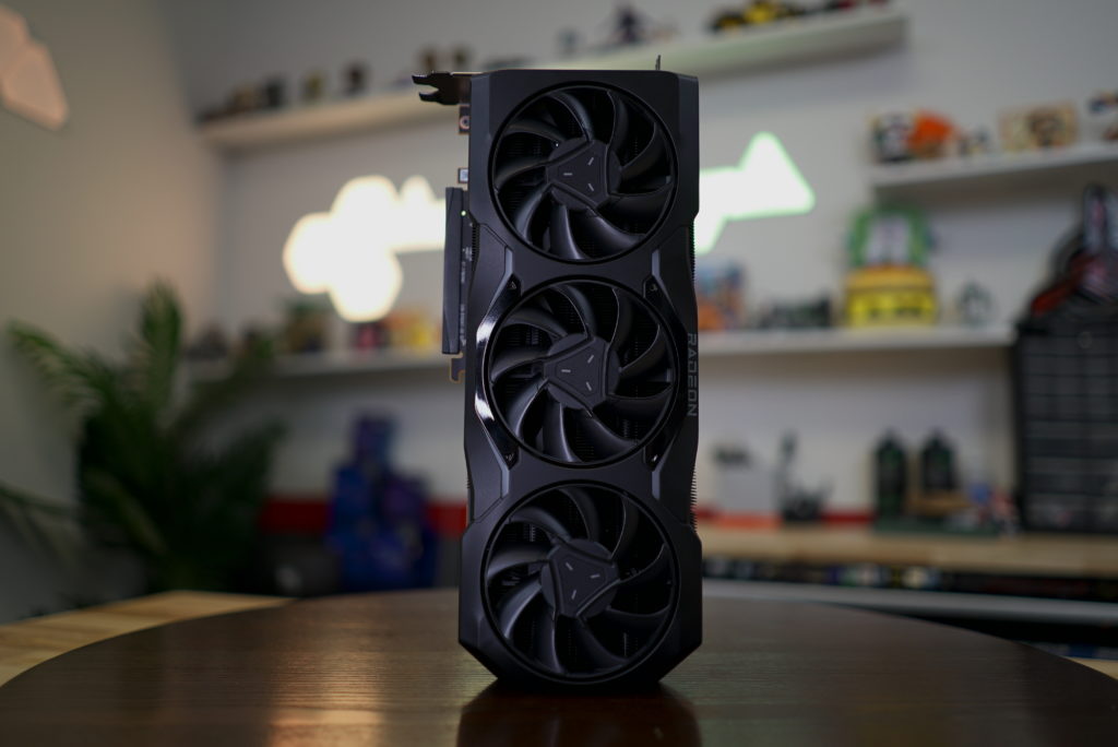 PC hardware component. Large graphics card with three fans standing vertically on a wooden table.